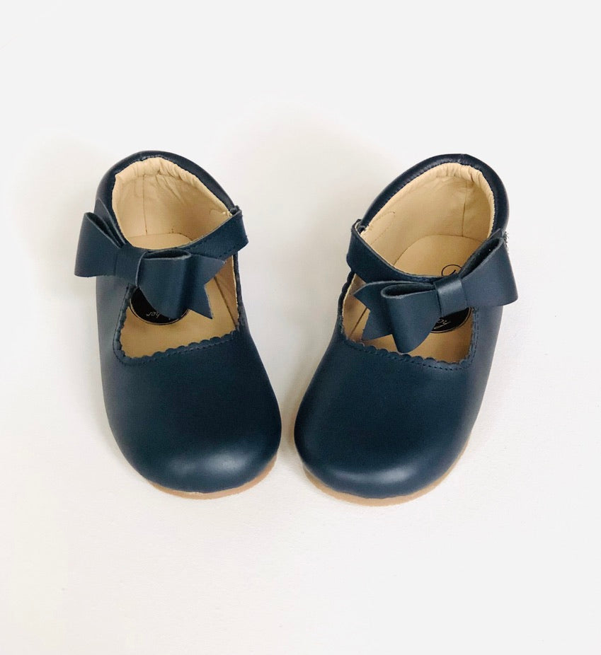 Classic navy blue leather baby Mary Jane shoes with scalloped trim, strap, and decorative bow, displayed on white background.