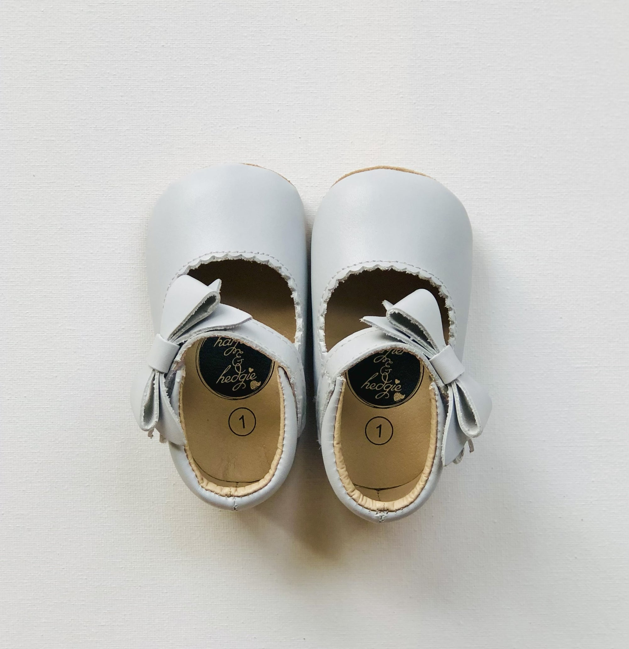 Sweet light gray leather baby Mary Jane shoes with soft soles, dainty front bows.