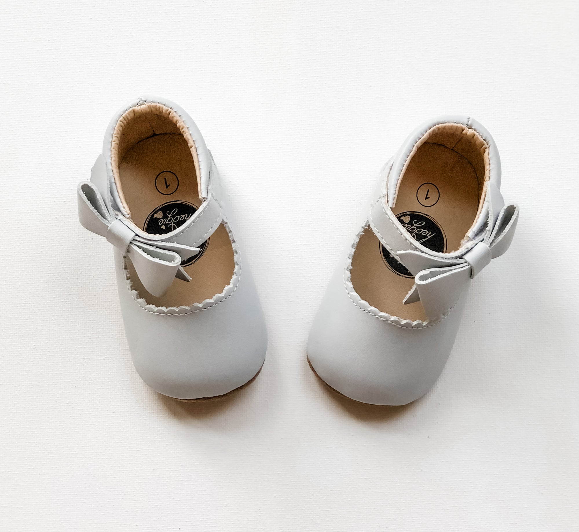 Adorable light gray toddler Mary Jane shoes with scalloped trim, front bow detail.