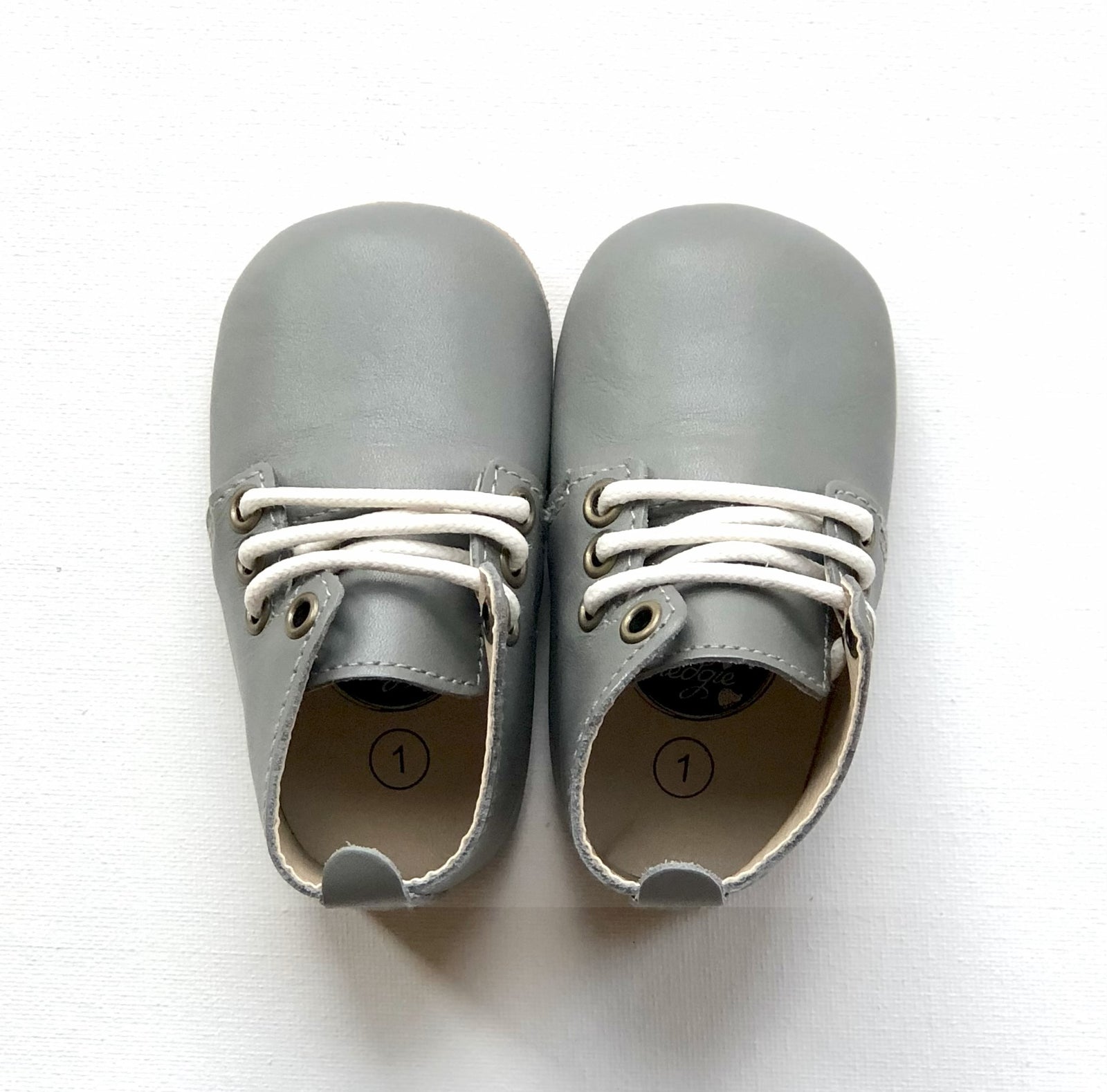 Pair of vintage grey leather baby oxfords with white laces and size 1 labels – soft sole shoes for infants