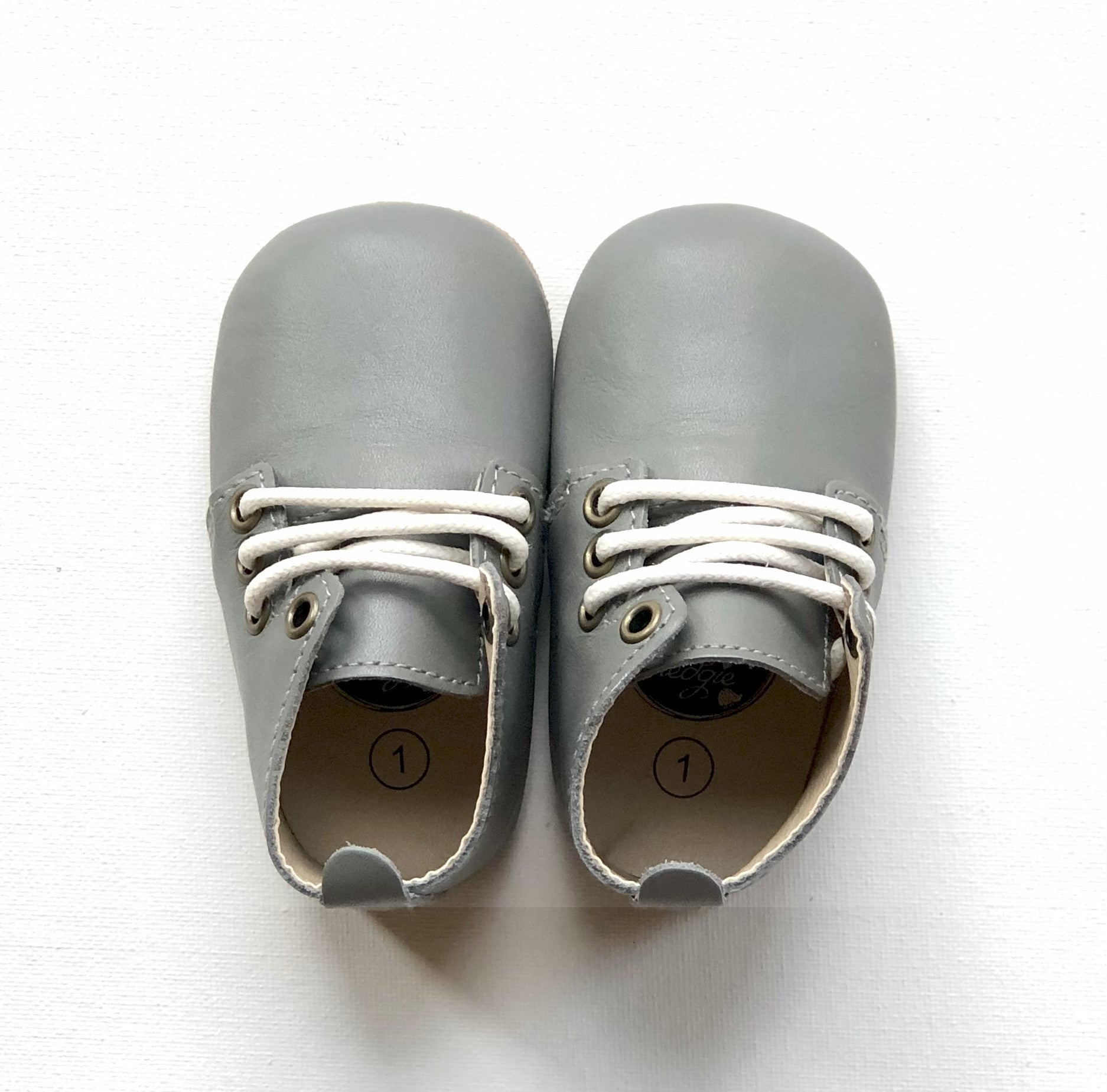 Pair of vintage grey leather baby oxfords with white laces and size 1 labels – soft sole shoes for infants