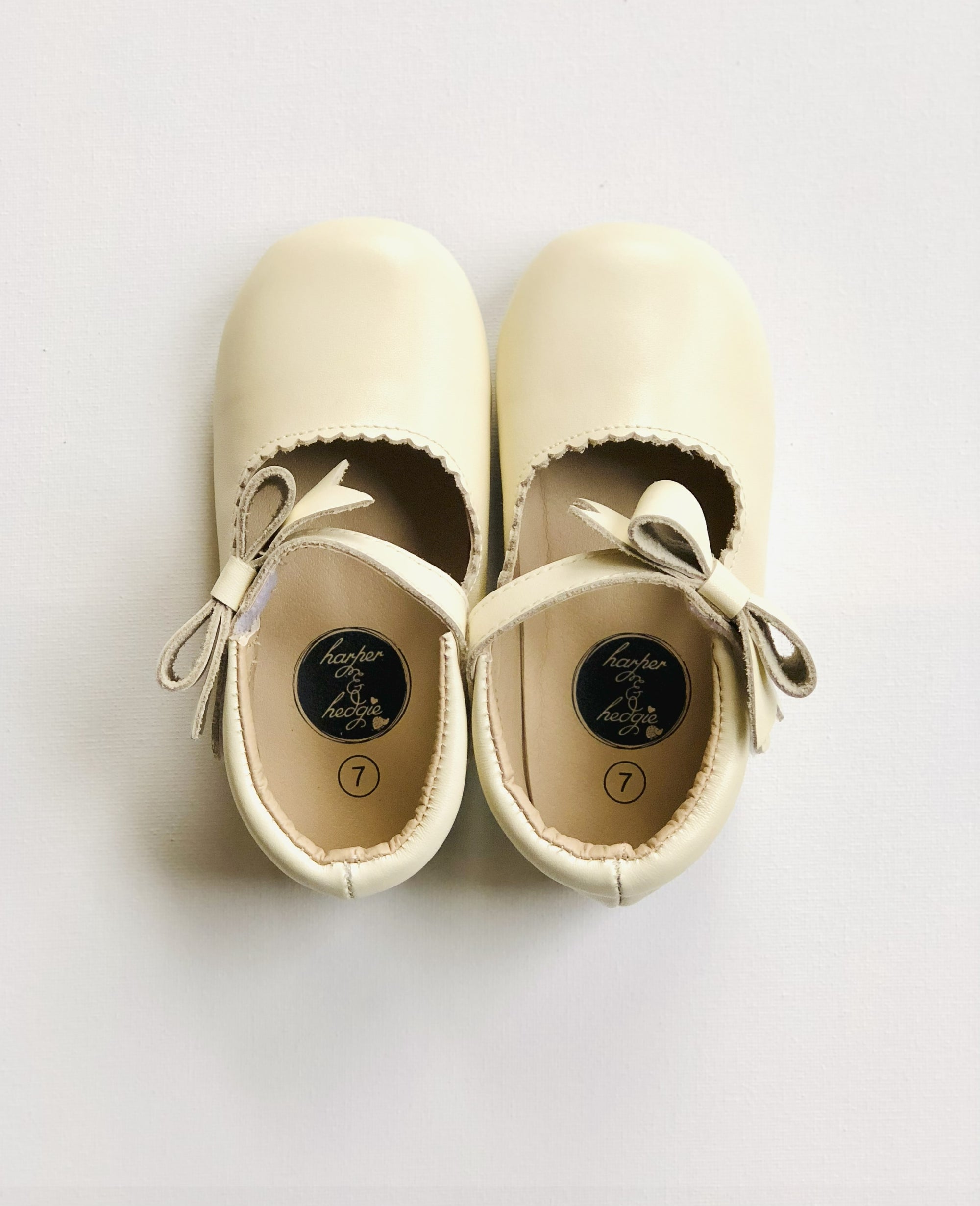Harper & Hedgie cream Mary Janes with strap and bow detail, displayed on white background with size label.