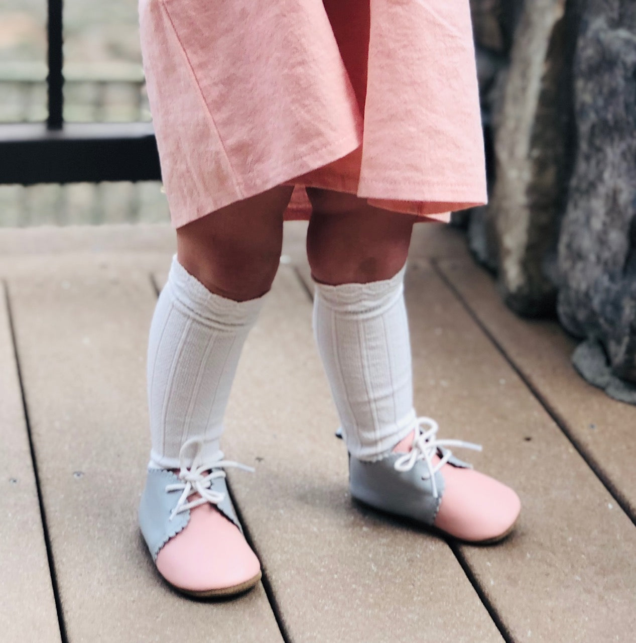 Child wearing white cable knit knee-high socks – perfect for everyday or special occasions